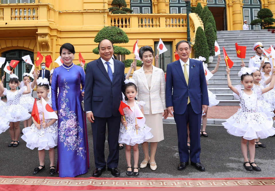 Thủ tướng Nguyễn Xuân Phúc và Phu nhân cùng Thủ tướng Nhật Bản Suga Yoshihide và Phu nhân với thiếu nhi Hà Nội tại Lễ đón. (Ảnh: Thống Nhất/TTXVN)