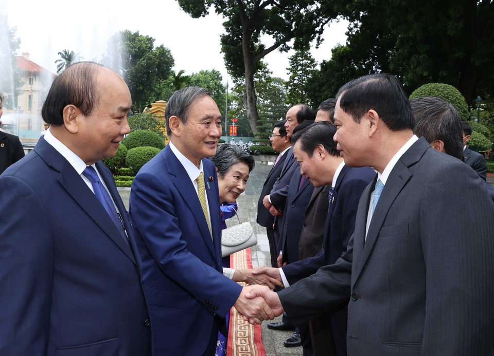 Thủ tướng Nhật Bản Suga Yoshihide với các thành viên chính thức Đoàn đại biểu Việt Nam tại Lễ đón. (Ảnh: Thống Nhất/TTXVN)
