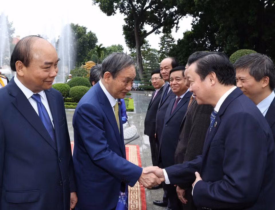 Thủ tướng Nhật Bản Suga Yoshihide với các thành viên chính thức Đoàn đại biểu Việt Nam tại Lễ đón. (Ảnh: Thống Nhất/TTXVN)