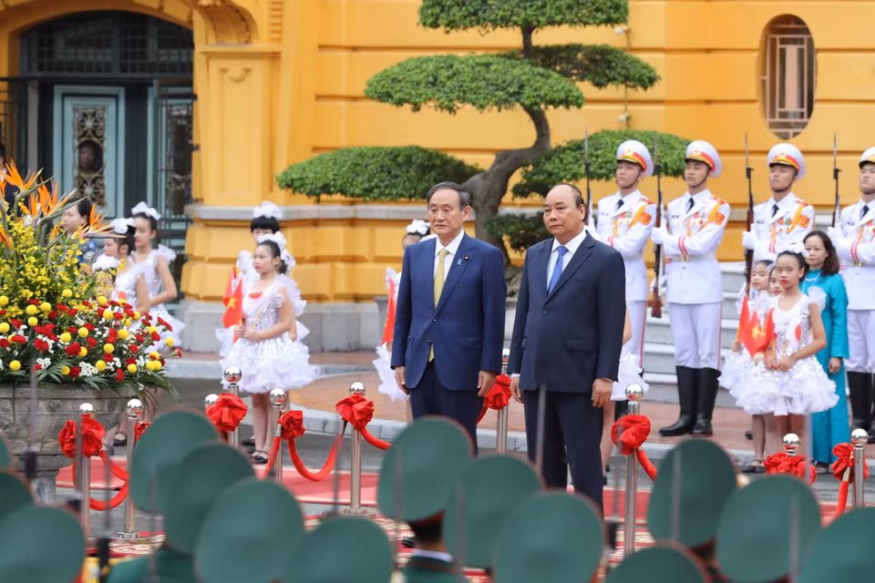 Thủ tướng Nguyễn Xuân Phúc và Thủ tướng Nhật Bản Suga Yoshihide trên bục danh dự, nghe quân nhạc cử Quốc thiều hai nước. (Ảnh: Lâm Khánh/TTXVN)