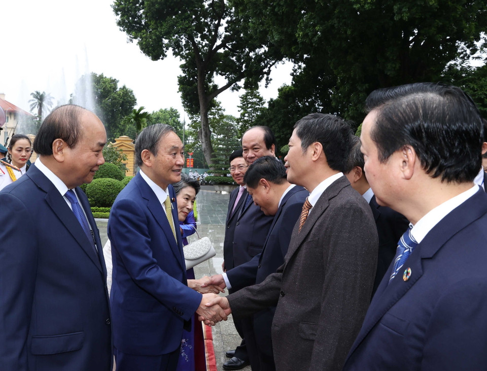Thủ tướng Nhật Bản Suga Yoshihide với các thành viên chính thức Đoàn đại biểu Việt Nam tại Lễ đón. (Ảnh: Thống Nhất/TTXVN)