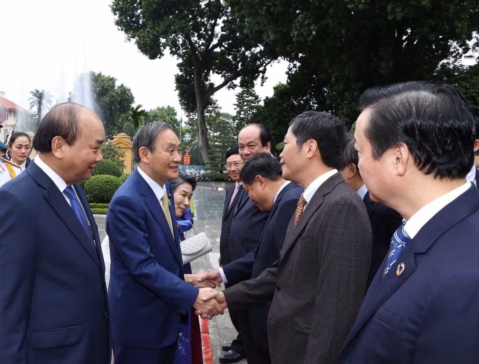 Thủ tướng Nhật Bản Suga Yoshihide với các thành viên chính thức Đoàn đại biểu Việt Nam tại Lễ đón. (Ảnh: Thống Nhất/TTXVN)