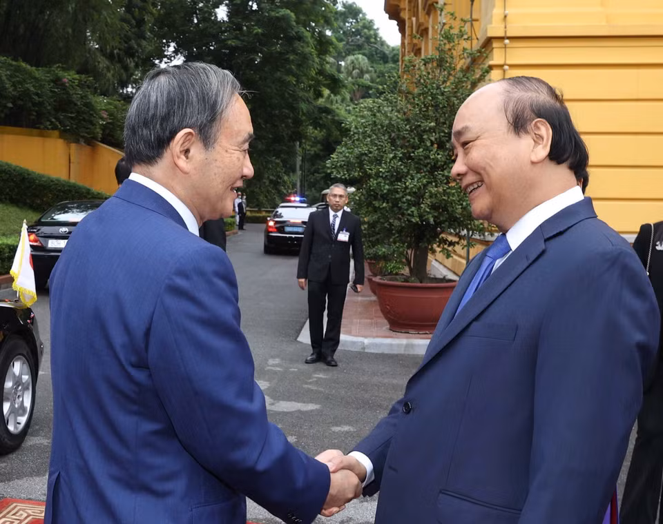 Thủ tướng Nguyễn Xuân Phúc đón Thủ tướng Nhật Bản Suga Yoshihide. (Ảnh: Thống Nhất/TTXVN)
