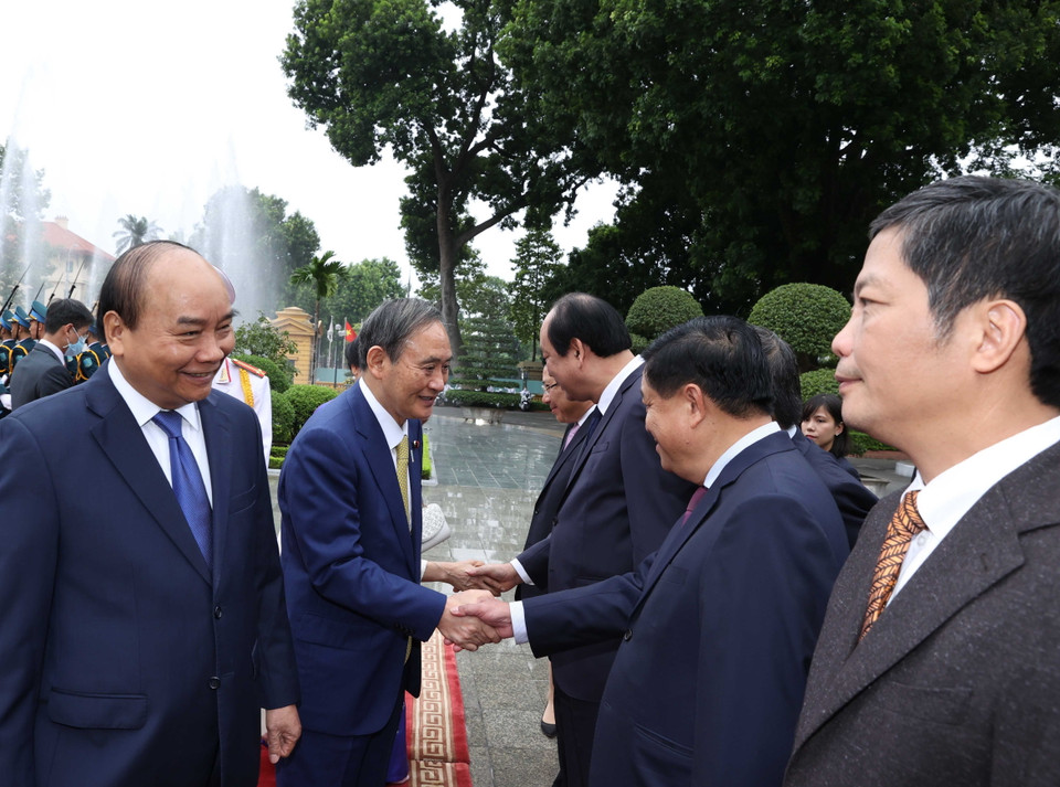 Thủ tướng Nhật Bản Suga Yoshihide với các thành viên chính thức Đoàn đại biểu Việt Nam tại Lễ đón. (Ảnh: Thống Nhất/TTXVN)
