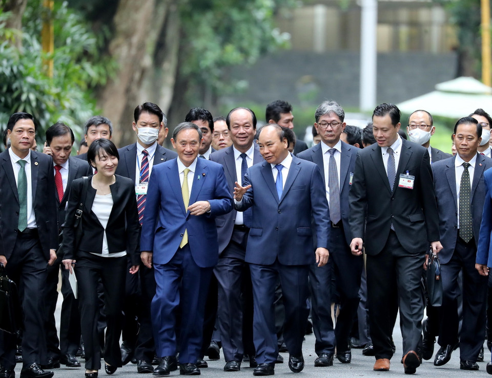 Thủ tướng Nguyễn Xuân Phúc và Thủ tướng Nhật Bản Suga Yoshihide đi dạo đường Xoài trong Khu Di tích Chủ tịch Hồ Chí Minh tại Phủ Chủ tịch. (Ảnh: Lâm Khánh/TTXVN)