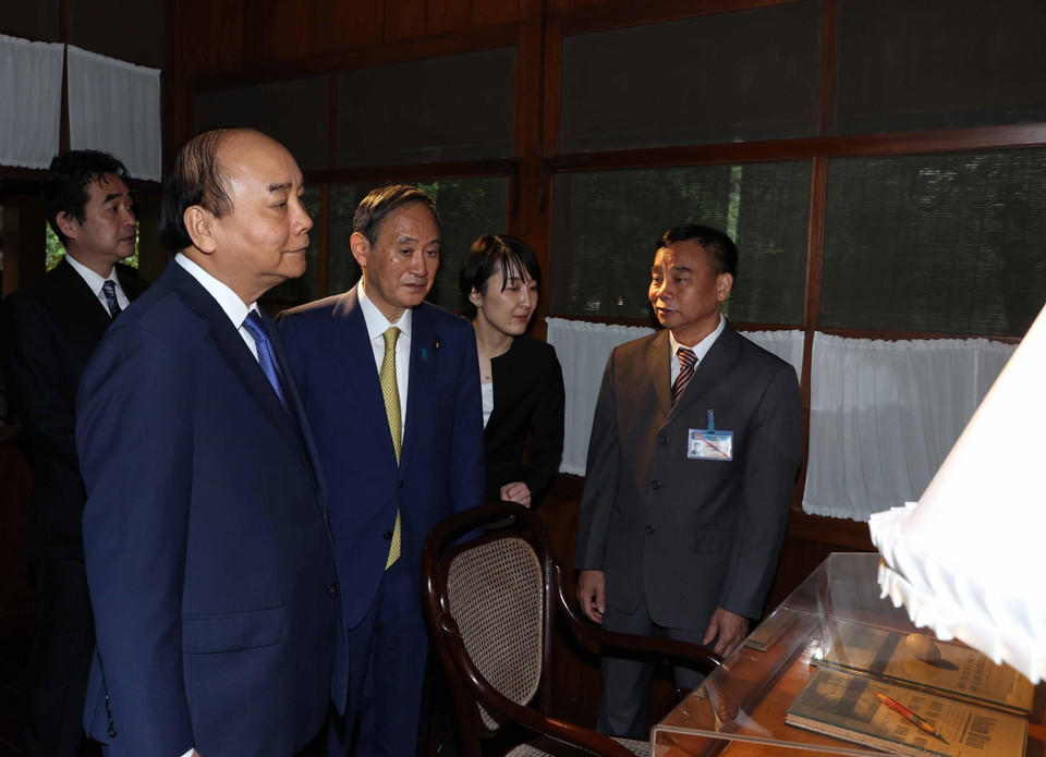 Thủ tướng Nguyễn Xuân Phúc và Thủ tướng Nhật Bản Suga Yoshihide tham quan Nhà sàn Bác Hồ trong Khu Di tích Chủ tịch Hồ Chí Minh tại Phủ Chủ tịch. (Ảnh: Thống Nhất/TTXVN)