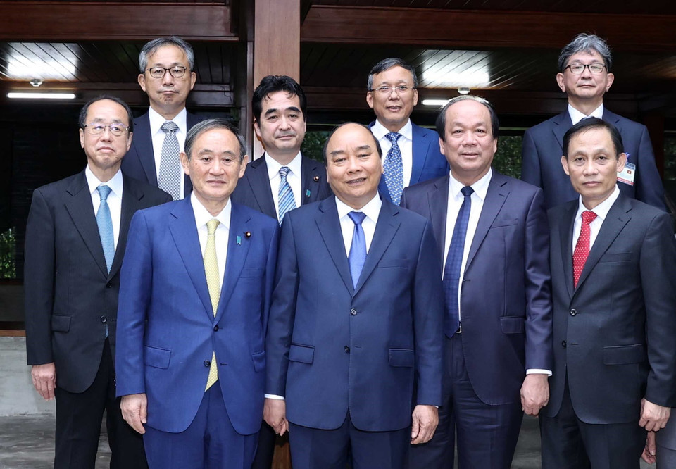 Thủ tướng Nguyễn Xuân Phúc và Thủ tướng Nhật Bản Suga Yoshihide tham quan Nhà sàn Bác Hồ trong Khu Di tích Chủ tịch Hồ Chí Minh tại Phủ Chủ tịch. (Ảnh: Thống Nhất/TTXVN)