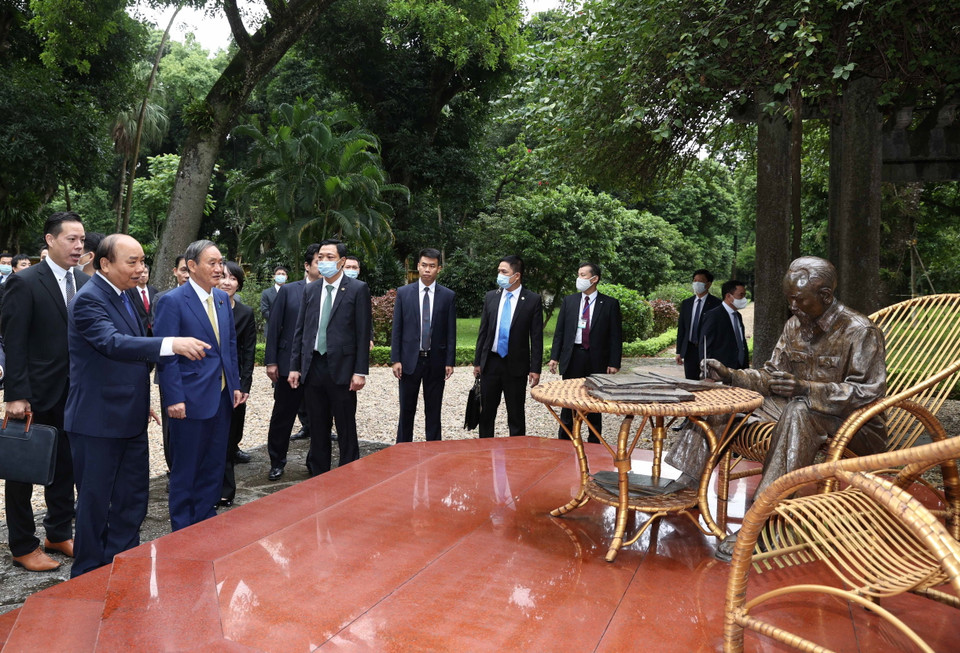 Thủ tướng Nguyễn Xuân Phúc và Thủ tướng Nhật Bản Suga Yoshihide tham quan nơi Bác Hồ đọc sách trong Khu Di tích Chủ tịch Hồ Chí Minh. (Ảnh: Thống Nhất/TTXVN)