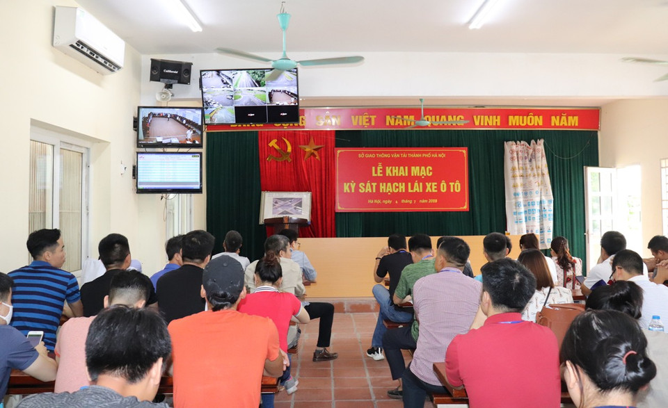 Thí sinh tập trung tại phòng hội trường của Trung tâm sát hạch và cấp giấy phép lái xe ôtô Đức Thịnh (Hà Nội) để mở đầu cho buổi sát hạch lái xe. (Ảnh: Việt Hùng/Vietnam+)