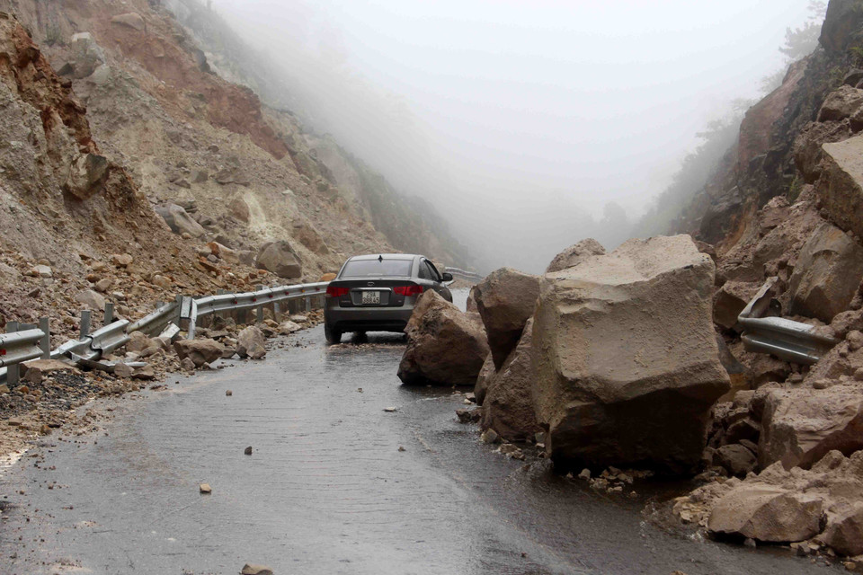 Hàng nghìn tấn đất đá bị sạt lở rơi xuống đường làm ảnh hưởng nghiêm trọng đến việc đi lại của người dân. (Ảnh: Công Tuyên/TTXVN)