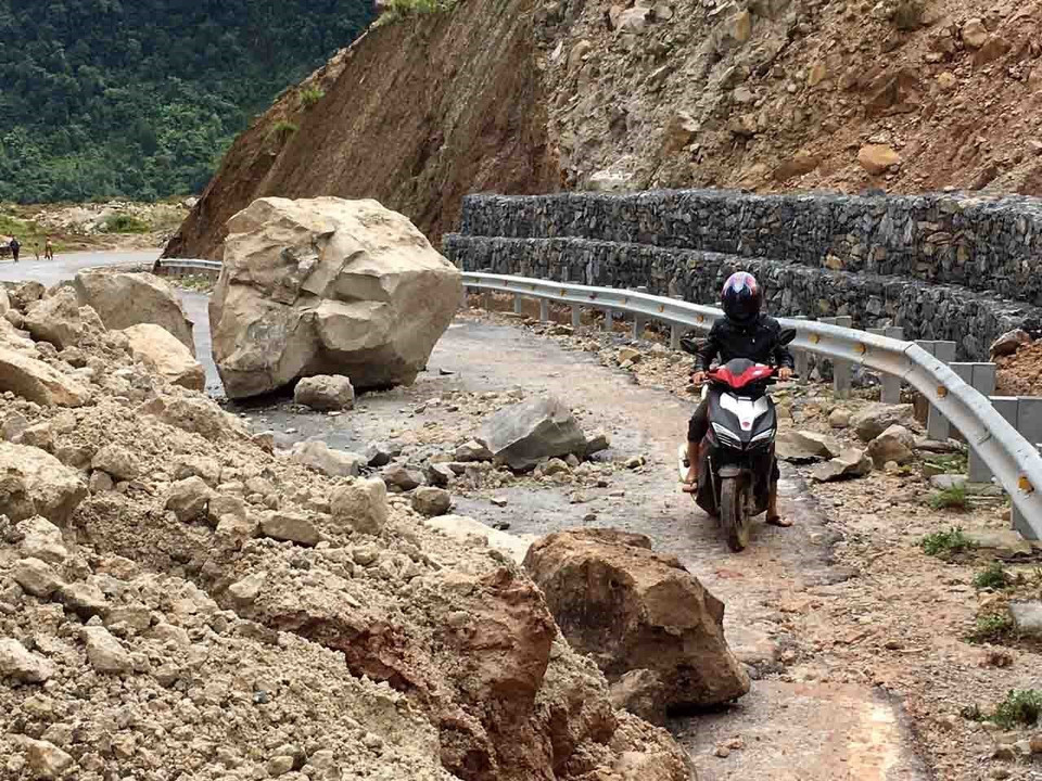 Hàng nghìn tấn đất đá bị sạt lở rơi xuống đường làm ảnh hưởng nghiêm trọng đến việc đi lại của người dân. (Ảnh: Công Tuyên/TTXVN)