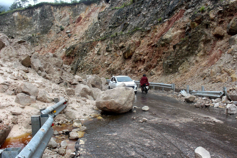 Hàng nghìn tấn đất đá bị sạt lở rơi xuống đường làm ảnh hưởng nghiêm trọng đến việc đi lại của người dân. (Ảnh: Công Tuyên/TTXVN)