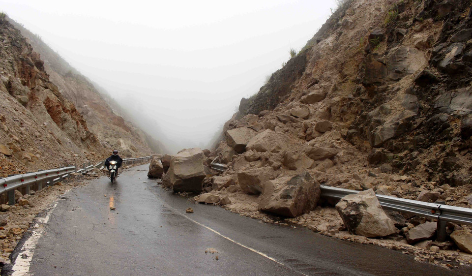 Hàng nghìn tấn đất đá bị sạt lở rơi xuống đường làm ảnh hưởng nghiêm trọng đến việc đi lại của người dân. (Ảnh: Công Tuyên/TTXVN)