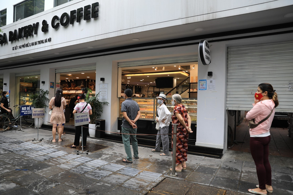 Một cửa hàng bánh trên phố Huế thực hiện nghiêm túc 5K yêu cầu khách đến mua xếp hàng đảm bảo giãn khoảng cách. (Ảnh: Tuấn Anh/TTXVN)