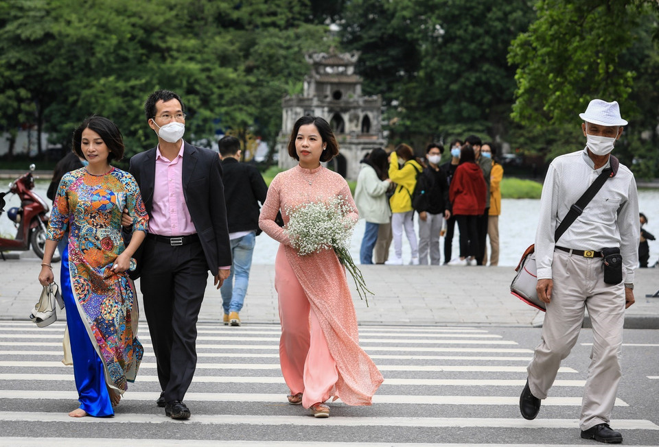 Tại khu vực hồ Hoàn Kiếm, một số người chủ quan người đeo, người không đeo khẩu trang đi dạo phố. (Ảnh: Thành Đạt/TTXVN)