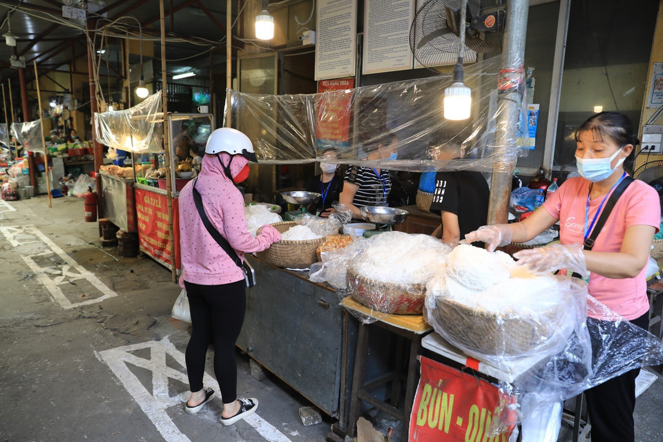Tại chợ Cống Vị (quận Ba Đình) thực hiện nghiêm quy định 5K, người dân đến mua phải quét mã QR-code và đứng giãn cách. (Ảnh: Thành Đạt/TTXVN)