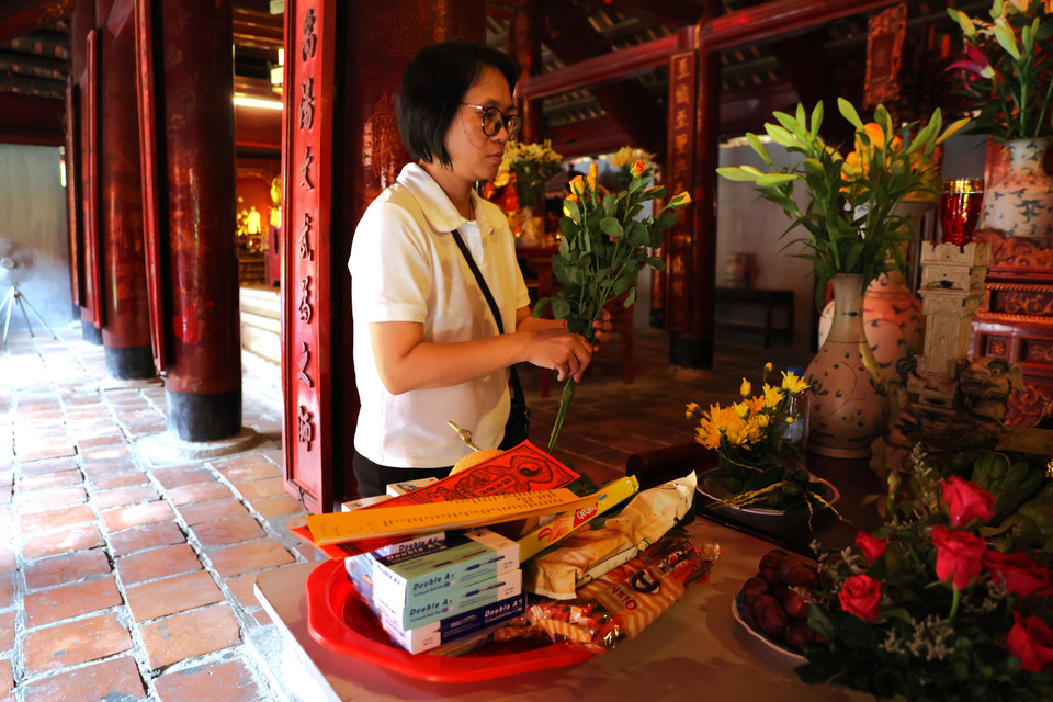 Đông đảo phụ huynh và sỹ tử có mặt để thắp hương trước ban thờ "Vạn thế sư biểu" Chu Văn An. (Ảnh: Minh Hiếu/Vietnam+)