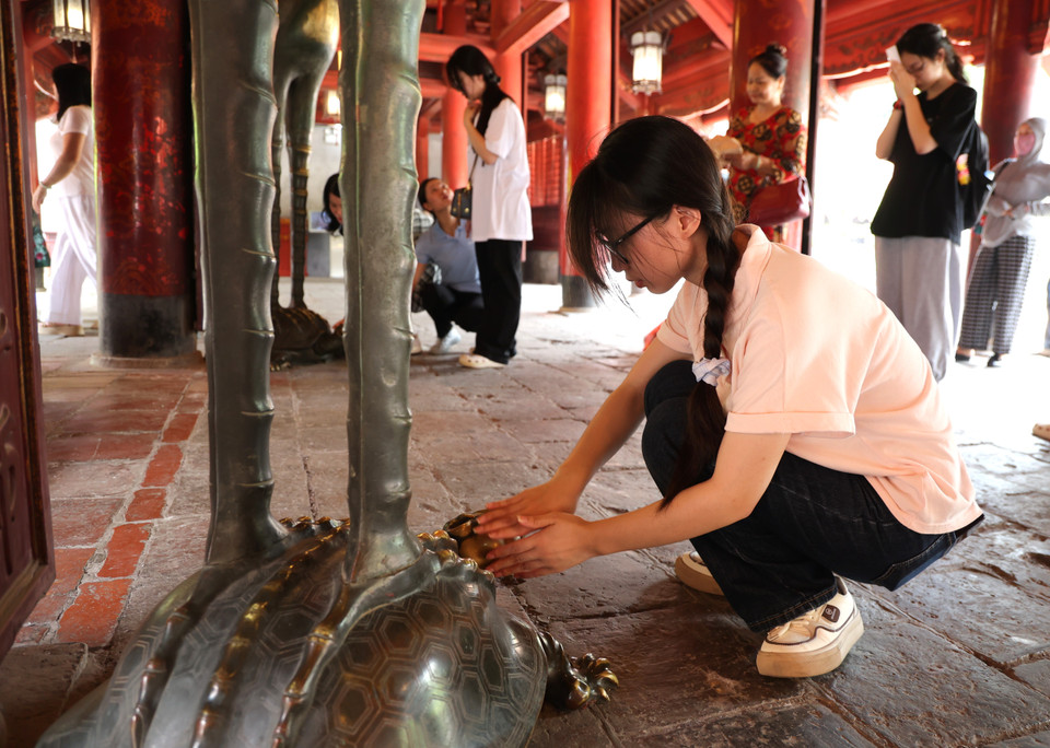 Nhiều sỹ tử sờ đầu rùa lấy may. (Ảnh: Minh Hiếu/Vietnam+)