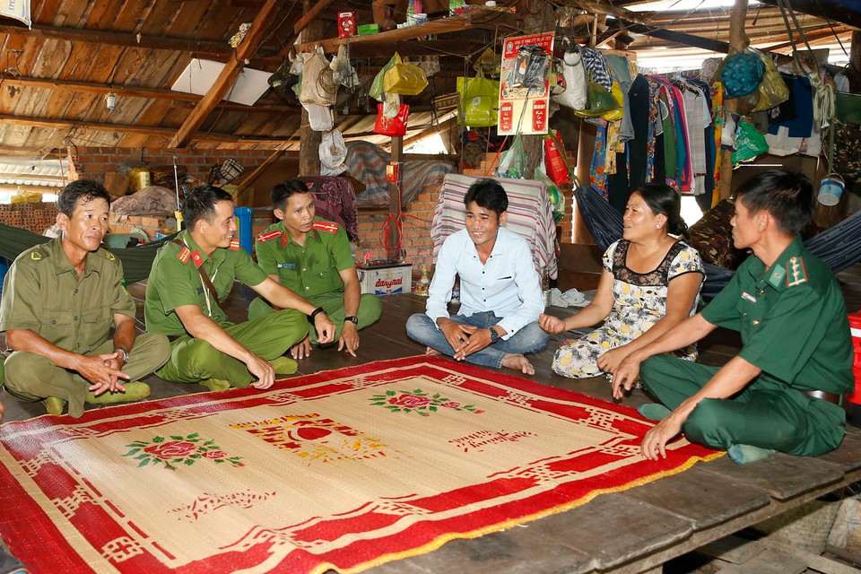 Công an chính quy và công an viên của xã Ia Rvê, huyện Ea Súp, tỉnh Đắk Lắk thăm hỏi nhân dân sống ở tuyến biên giới phía Tây Bắc giáp với Vương quốc Campuchia. (Ảnh: Doãn Tấn/TTXVN)