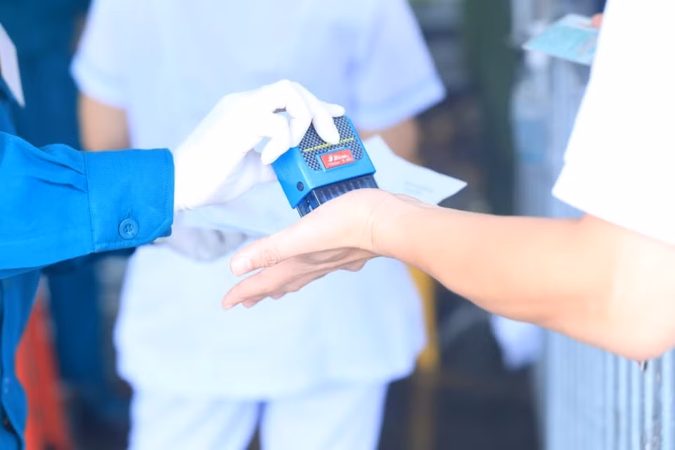 Lực lượng chức năng đóng dấu kiểm tra y tế cho người đủ giấy tờ quy định được vào Hà Nội. (Ảnh: Tuấn Anh/TTXVN)