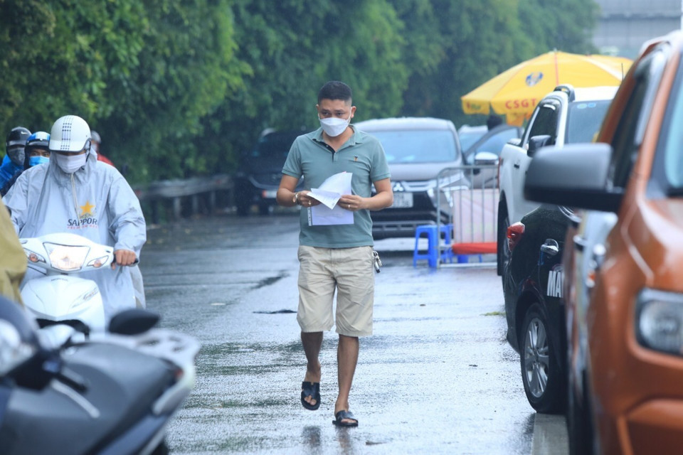 Một lái xe xuống xuất trình giấy tờ khi qua chốt kiểm dịch số 5 cầu Phù Đổng. (Ảnh: Tuấn Anh/TTXVN)