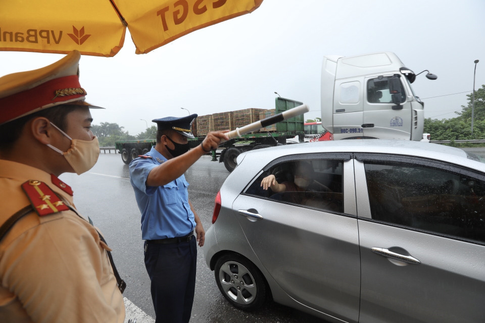 Khi kiểm tra giấy tờ xong, người đủ điều kiện sẽ được đóng dấu vào tay để lưu thông qua chốt. (Ảnh: Minh Quyết/TTXVN)