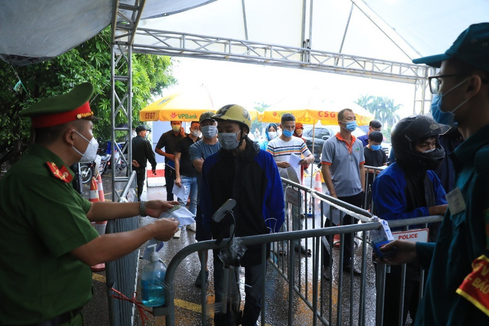 Lực lượng chức năng kiểm tra giấy tờ của người dân vào Hà Nội tại chốt kiểm soát dịch số 5 - cầu Phù Đổng. (Ảnh: Tuấn Anh/TTXVN)