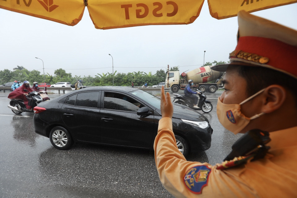 Khi kiểm tra giấy tờ xong, người đủ điều kiện sẽ được đóng dấu vào tay để lưu thông qua chốt. (Ảnh: Minh Quyết/TTXVN)