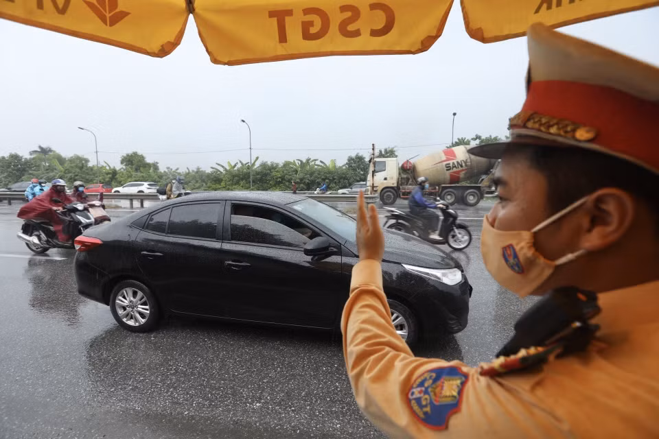 Khi kiểm tra giấy tờ xong, người đủ điều kiện sẽ được đóng dấu vào tay để lưu thông qua chốt. (Ảnh: Minh Quyết/TTXVN)