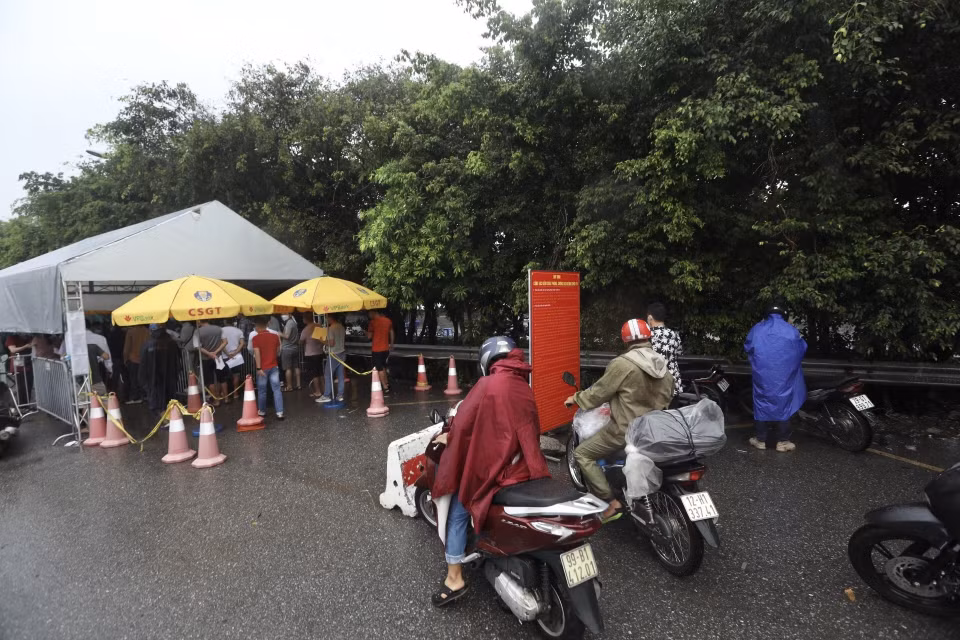 Người tham gia giao thông qua chốt kiểm soát cầu Phù Đổng (huyện Gia Lâm) phải qua kiểm tra giấy tờ, khai báo y tế trước khi vào nội đô.(Ảnh: Minh Quyết/TTXVN)