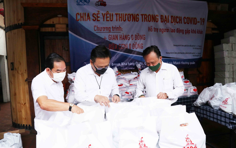 Ông Phùng Công Dũng, Chủ nhiệm Ủy ban về Người Việt Nam ở nước ngoài TP. Hồ Chí Minh (ngoài cùng bên phải), ông Lê Bá Linh, kiều bào Thái Lan, Chủ tịch HĐQT công ty Cổ phần Pacific Foods (giữa) kiểm tra các phần quà cho người dân nghèo đến với Siêu thị 0 đồng. (Ảnh: Xuân Khu/TTXVN)