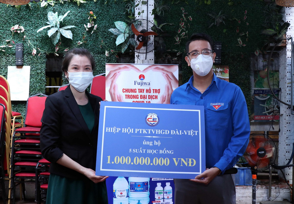 Bà Ngô Phẩm Trân, kiều bào Đài Loan (Trung Quốc), Chủ tịch Hiệp hội phát triển kinh tế Đài Loan-Việt Nam trao tượng trưng 5 học bổng trị giá 1 tỷ đồng cho ông Phan Lê Huy Hoàng, Bí thư Quận đoàn quận Tân Bình. (Ảnh: Xuân Khu/TTXVN)