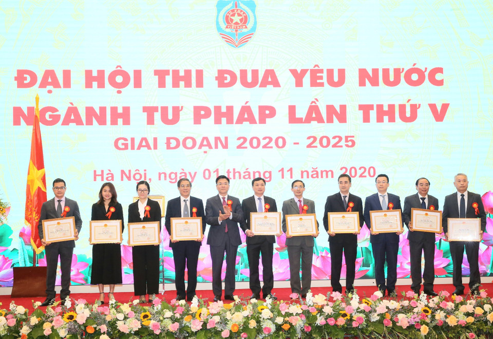 Bộ trưởng Bộ Tư pháp Lê Thành Long trao tặng Bằng khen cho các tập thể, cá nhân có thành tích xuất sắc. (Ảnh: Doãn Tấn/TTXVN)