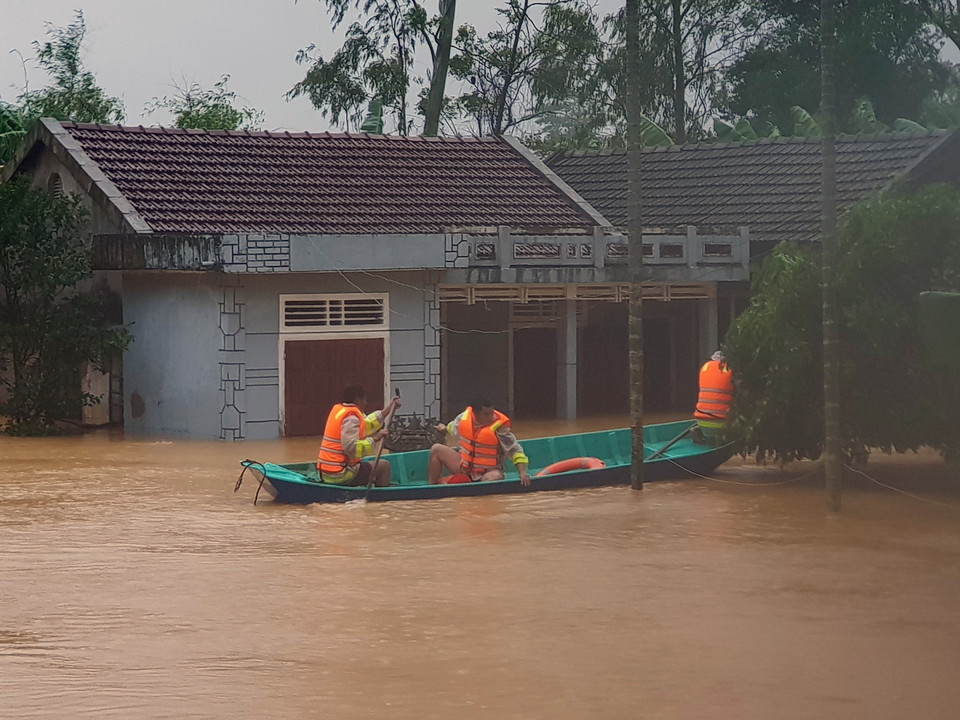 Di chuyển người dân ra khỏi khu vực ngập lũ tại huyện Cam Lộ (Quảng Trị). (Ảnh: Thanh Thủy/TTXVN)