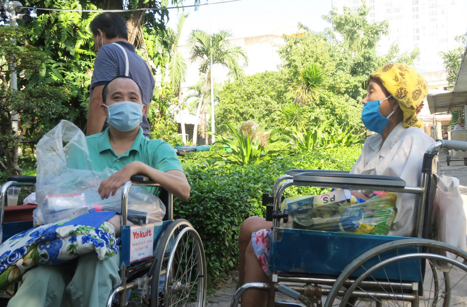 Các bệnh nhân chờ người thân mua hàng tại Phiên chợ 0 đồng. (Ảnh: Đinh Hằng/TTXVN)