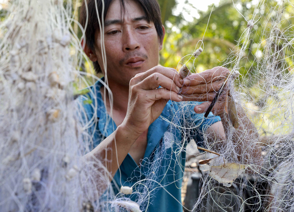 Người dân Hậu Giang giăng lưới bắt cá trên ruộng mùa nước nổi. (Ảnh: Duy Khương/TTXVN)