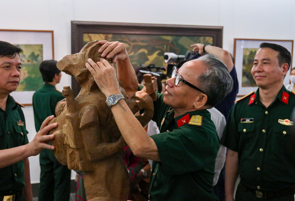 Đại tá, Anh hùng Lực lượng vũ trang nhân dân Lê Duy Ứng với tác phẩm điêu khắc “Bài ca người mẹ.” (Ảnh: Minh Hiếu/Vietnam+)