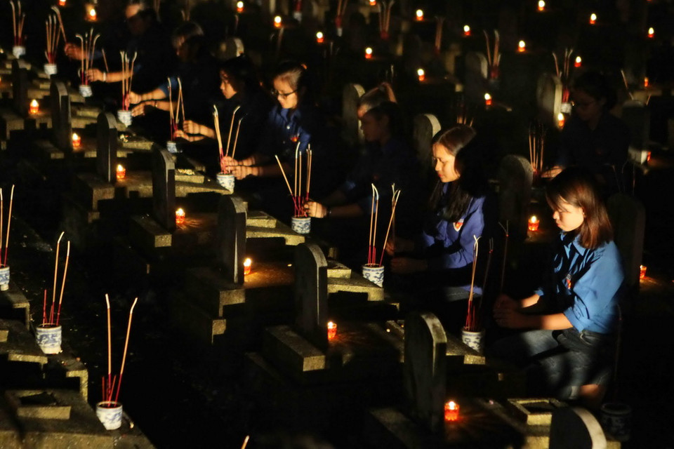 Tuổi trẻ Nghệ An dâng hương tưởng niệm các anh hùng liệt sỹ bên các phần mộ. (Ảnh: Thanh Tùng/TTXVN)