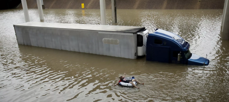 Tài xế xe tải bất lực và đành lấy phao ra để 'thư giãn.' (Nguồn: AP)
