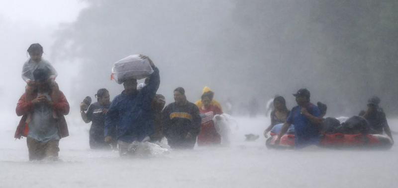 Người dân lội nước để sơ tán. (Nguồn: Reuters)