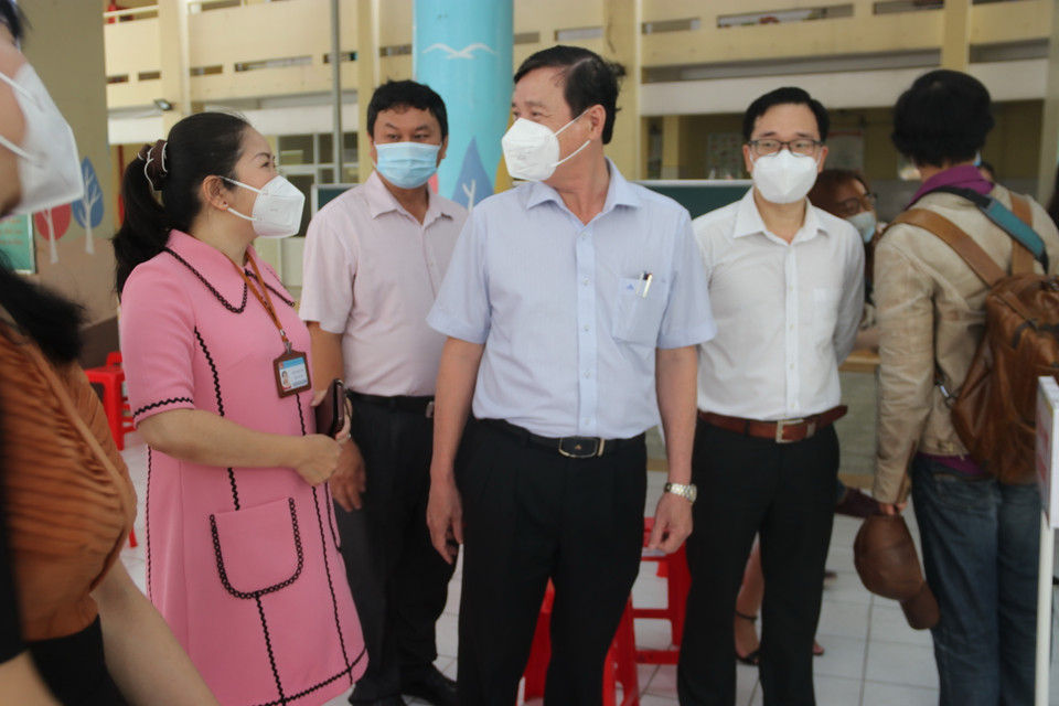 Phó Giám đốc Sở Y tế Thành phố Hồ Chí Minh Nguyễn Hữu Hưng khảo sát tại điểm tiêm trường Tiểu học Nguyễn Bỉnh Khiêm (quận 1). (Ảnh: Thu Hương/TTXVN)