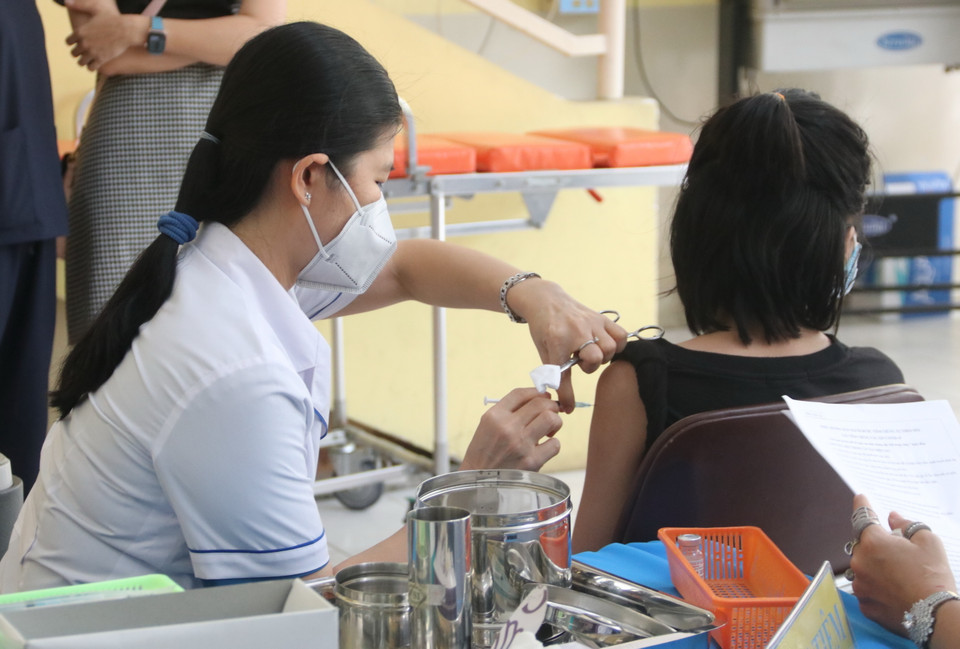 Nhân viên y tế tiêm vaccine phòng COVID-19 cho học sinh tại trường Tiểu học Nguyễn Bỉnh Khiêm (quận 1). (Ảnh: Thu Hương/TTXVN)