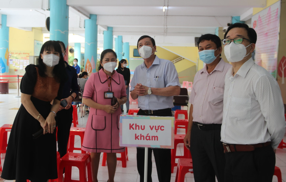 Phó Giám đốc Sở Y tế Thành phố Hồ Chí Minh Nguyễn Hữu Hưng khảo sát tại điểm tiêm trường Tiểu học Nguyễn Bỉnh Khiêm (quận 1). (Ảnh: Thu Hương/TTXVN)
