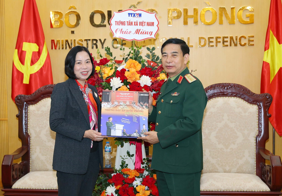 Tổng Giám đốc Vũ Việt Trang tặng cuốn sách ảnh của Thông tấn xã Việt Nam cho Đại tướng, Bộ trưởng Quốc phòng Phan Văn Giang. (Ảnh: Trọng Đức/TTXVN)