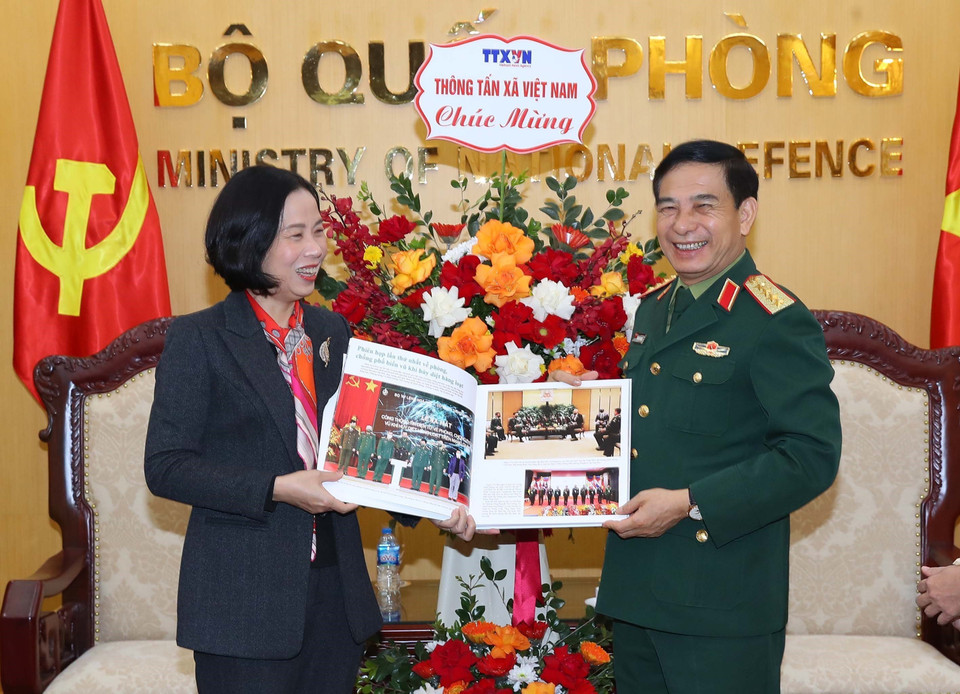 Tổng Giám đốc Vũ Việt Trang tặng cuốn sách ảnh của Thông tấn xã Việt Nam cho Đại tướng, Bộ trưởng Quốc phòng Phan Văn Giang. (Ảnh: Trọng Đức/TTXVN)