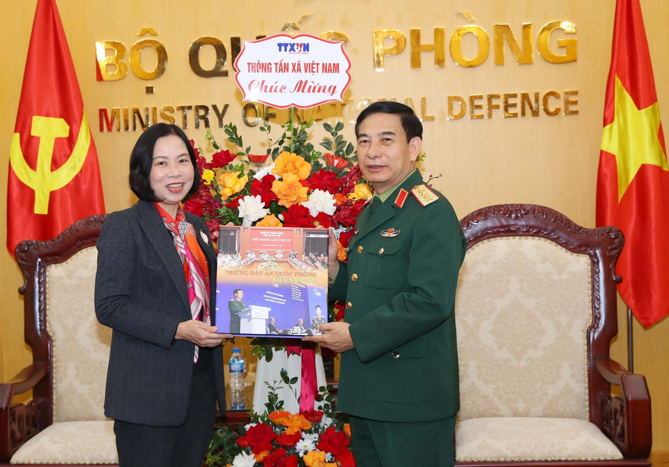 Tổng Giám đốc Vũ Việt Trang tặng cuốn sách ảnh của Thông tấn xã Việt Nam cho Đại tướng, Bộ trưởng Quốc phòng Phan Văn Giang. (Ảnh: Trọng Đức/TTXVN)
