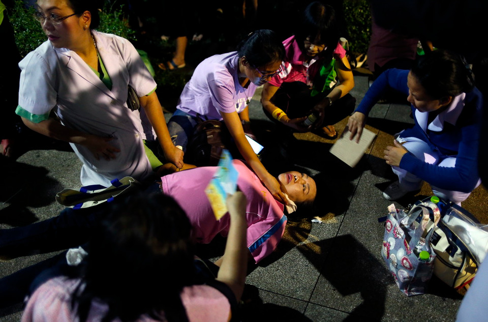 Một phụ nữ ngất xỉu sau khi nghe thông tin Nhà Vua qua đời. (Nguồn: EPA)