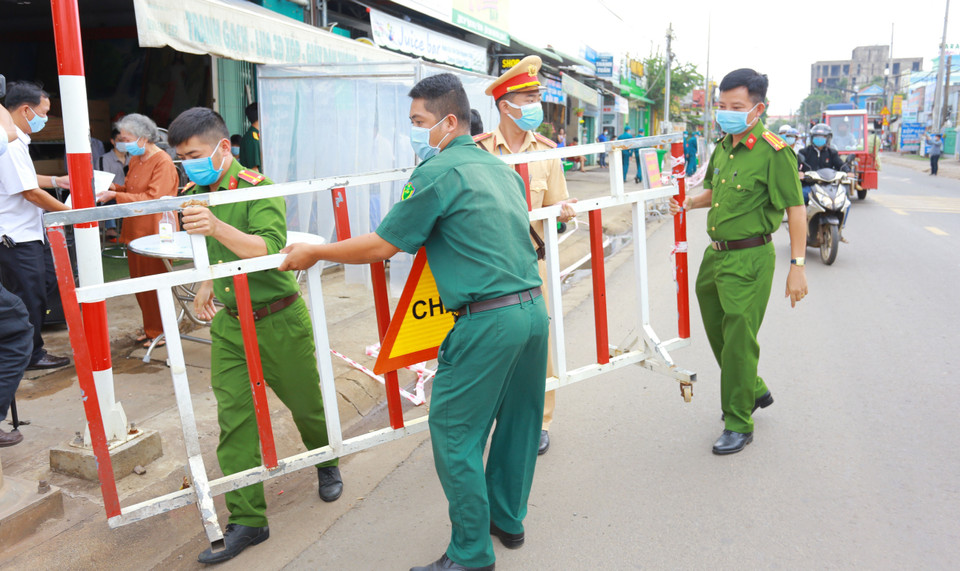 Lực lượng chức năng thực hiện dỡ bỏ phong tỏa cho 20 hộ dân tại khu phố 2, phường Xuân Thanh. (Ảnh: Lê Xuân/TTXVN)