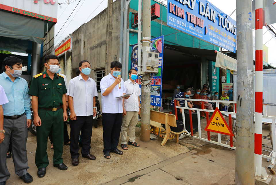 Đại diện chính quyền địa phương đọc lệnh dỡ bỏ phong tỏa đối với 20 hộ dân tại khu phố 2, phường Xuân Thanh. (Ảnh: Lê Xuân/TTXVN)