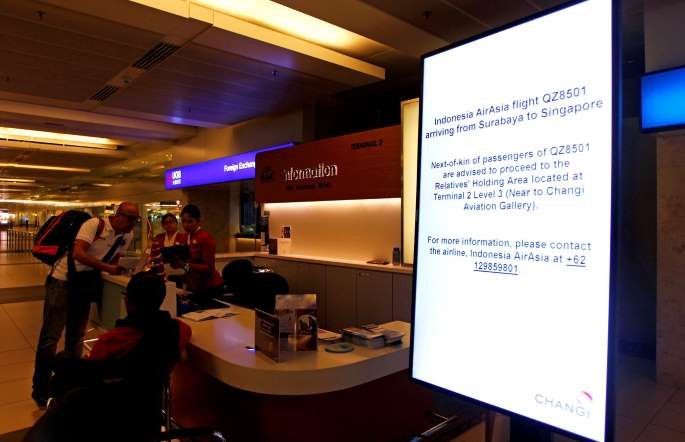 Thông báo về việc tiếp đón thân nhân của hành khách trên chiếc máy bay QZ8501 bên một quầy thông tin ở sân bay Changi, Singapore. (Nguồn: Reuters)